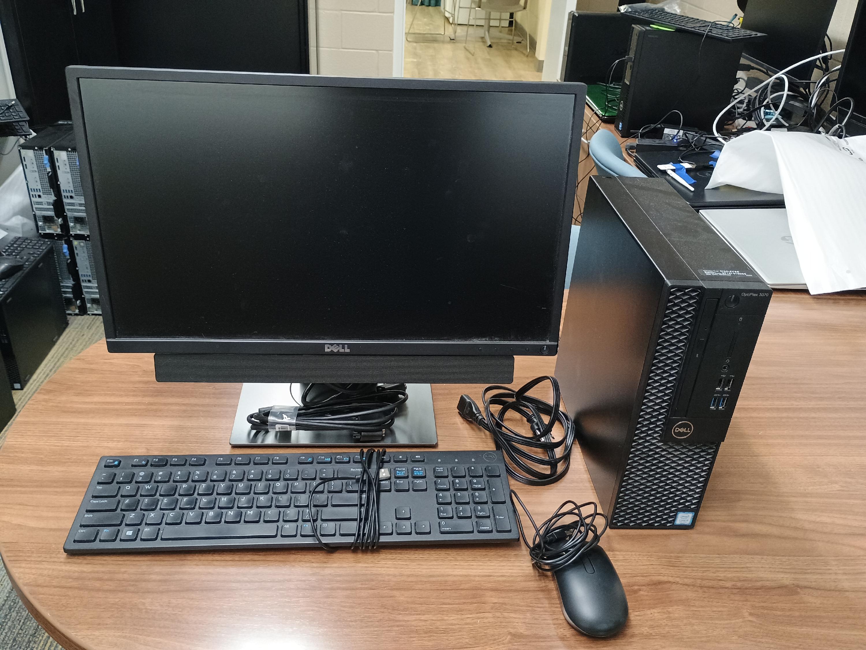 Desktop computer with monitor, keyboard, mouse, soundbar and cables.